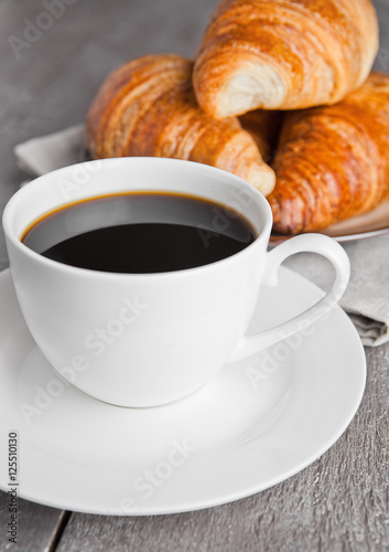 Cup of black coffee and croissant for breakfast