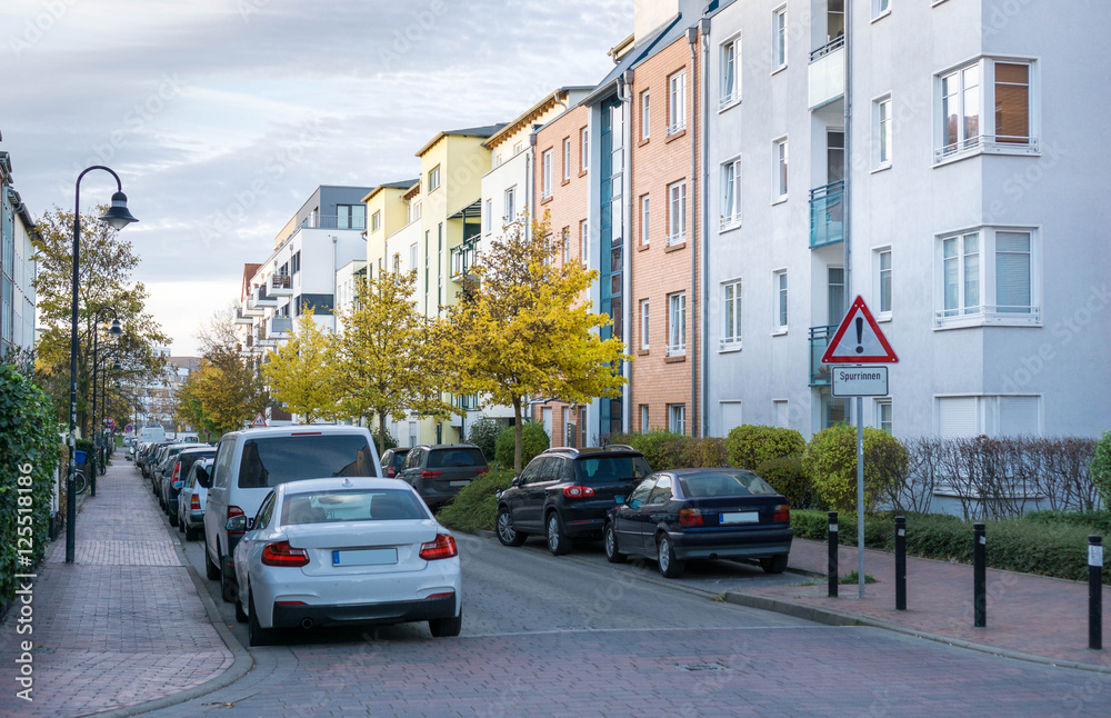 Straße mit parkenden Autos und Wohnhäuser in einer Stadt - Rostock