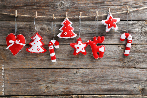 Christmas decorations hanging on rope on wooden background