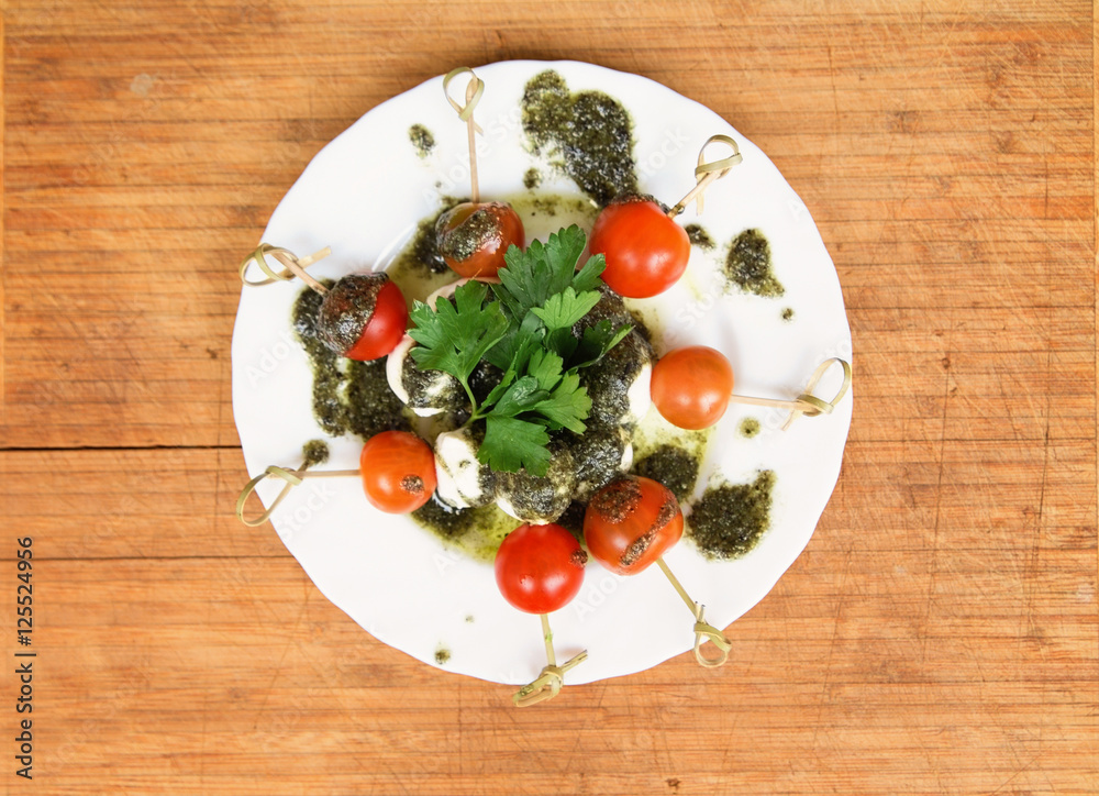 Caprese salad tomato and mozzarella with parsley and herbs on a Caprese salad tomato and mozzarella with parsley and herbs on a