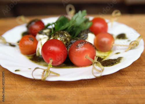 Caprese salad tomato and mozzarella with parsley and herbs on a