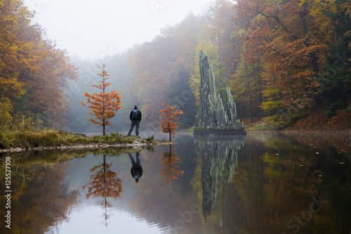 Traveler near Rakotzbrücke (Devil's bridge) in early morning mist photo