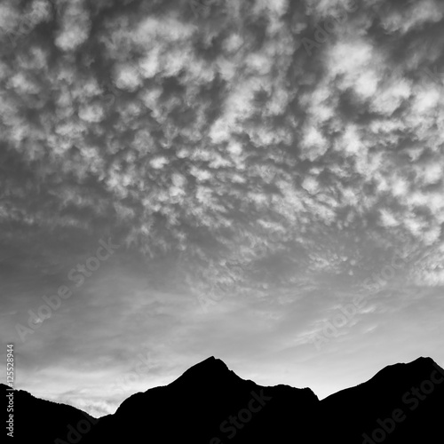 Quiet evening. Clouds over the mountains. After sunset in black and white