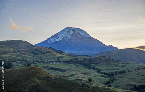 View of the Chimborazo volcano in semi silhouette and surrounding Andes mountains, on a sunny morning. Bolivar Province, Ecuador