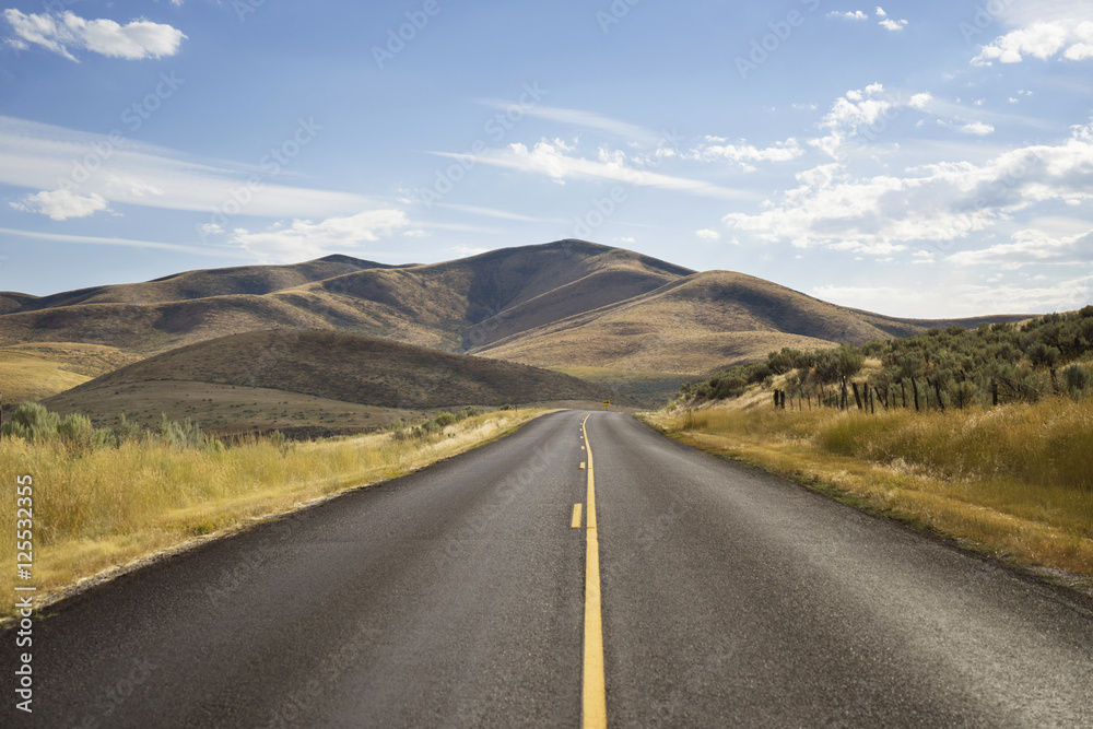 Empty country road against sky on sunny day