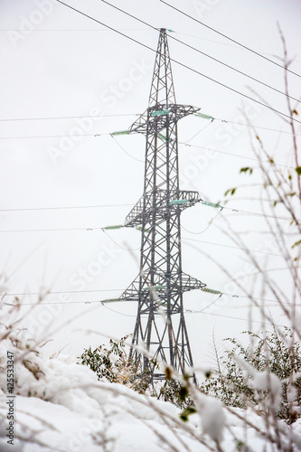 A high voltage power pylons, winter in snowy weather.