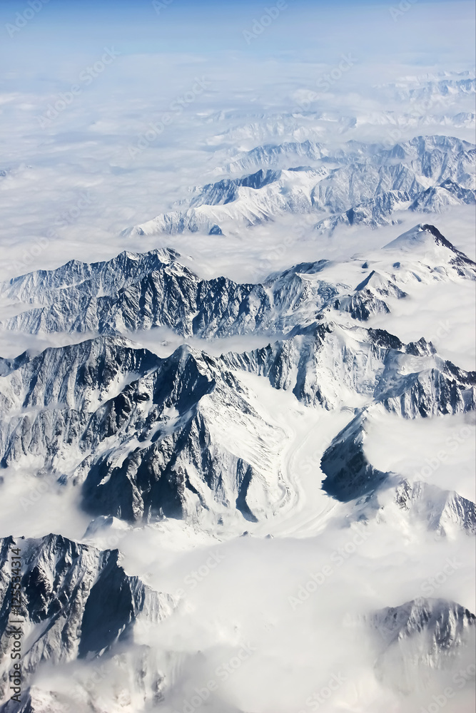 Fototapeta premium Mountains in snow and clouds. View from above. Winter nature.