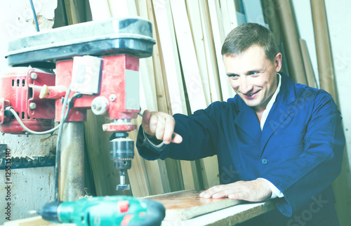 man in uniform choosing compressed densified wood photo