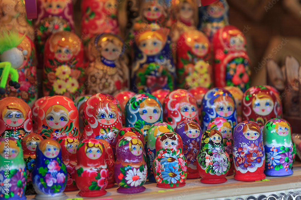 Colorful close up details of christmas fair market. Wooden matrioshka decorations for sales. Russian dolls