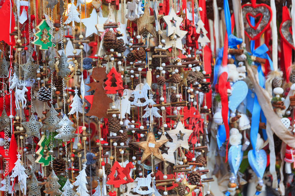 Fototapeta premium Colorful close up details of christmas fair market. Stars, hearts, tree, fir-cone balls decorations for sales.