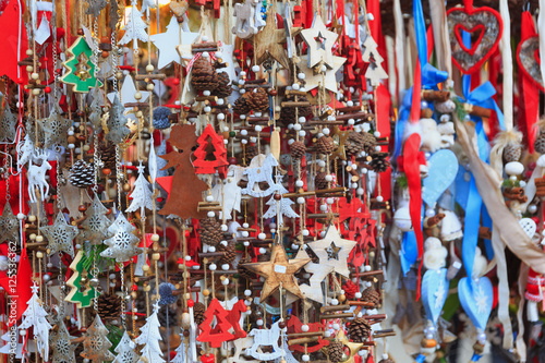 Colorful close up details of christmas fair market. Stars, hearts, tree, fir-cone balls decorations for sales.