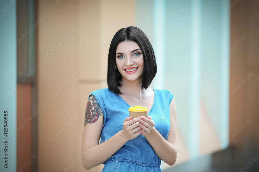 Young beautiful girl outdoors with cup of coffee Young beautiful girl outdoors with cup of coffee