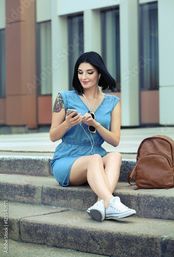 Beautiful young woman listening to music outdoor
