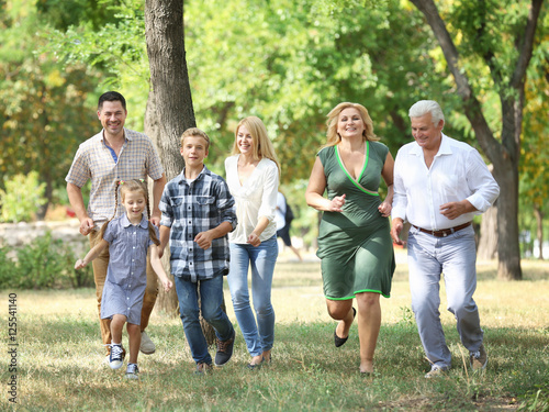 Large happy family walking in park