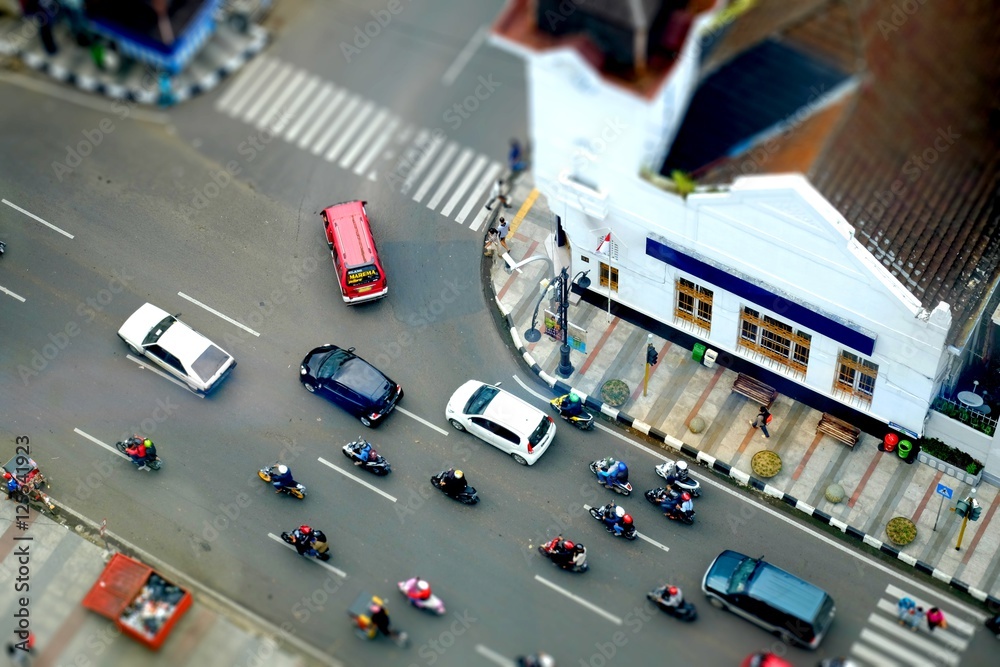 Traffic intersection with cars and motorcycles, in asia afrika street, bandung, Indonesia in tilt shit, miniature