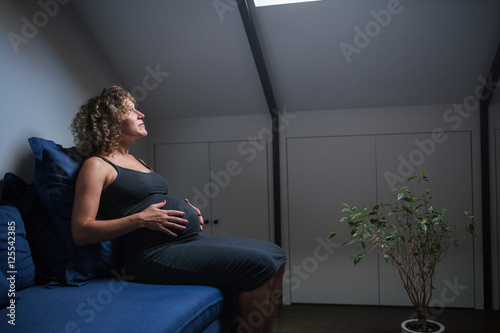 Bild auf Leinwand mature pregnant pensive woman at home