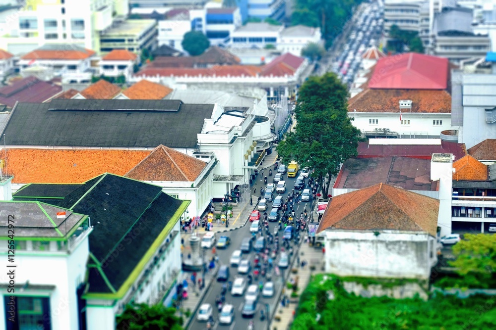 Busy hour in Asia Afrika Street, in Bandung, Indonesia. With many motorcycles and cars in the road, seen from top, tilt shift