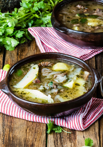 Traditional chilean latinamerican meat soup ajiaco served in clay plate photo