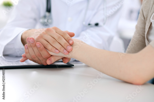 Hand of doctor reassuring her female patient