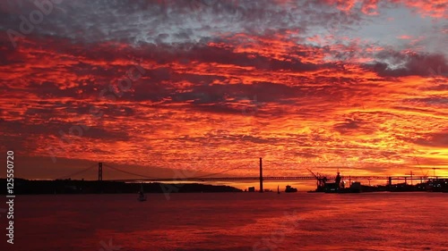 fabulous bloody sunset over Tagus river over 25th April Bridge Lisbon photo