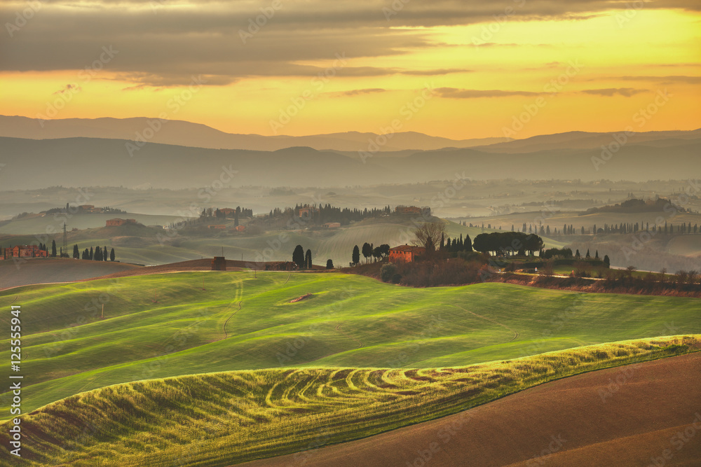 Tuscany spring, rolling hills on misty sunset. Rural landscape.