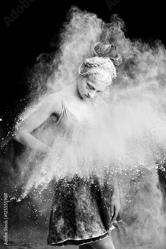 Graceful woman dancing in cloud of dust 