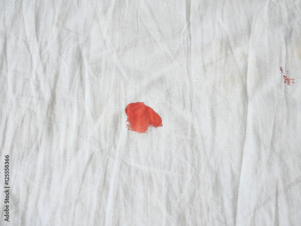 Fotka „Red period spot on white bed sheet. Period stain is hard to be