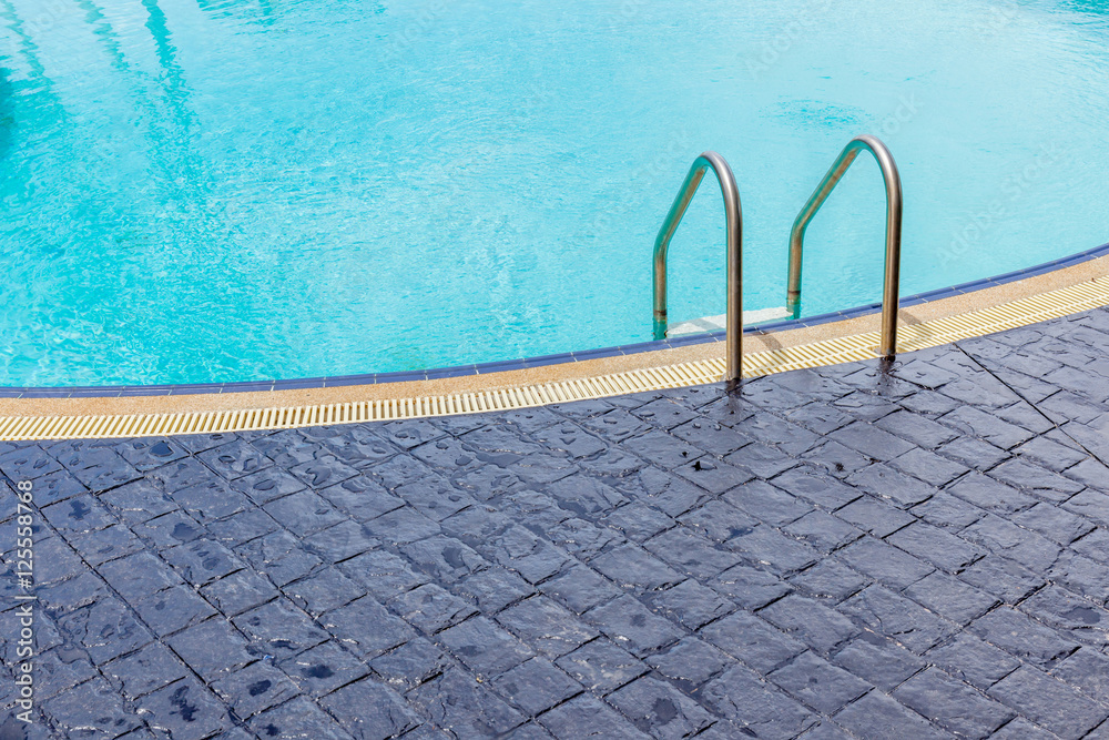 The view of metallic ladder entrance to clear blue swimming pool The view of metallic ladder entrance to clear blue swimming pool