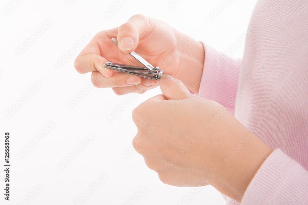 closeup of a woman cutting nails on white background. closeup of a woman cutting nails on white background.