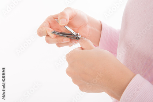 closeup of a woman cutting nails on white background.