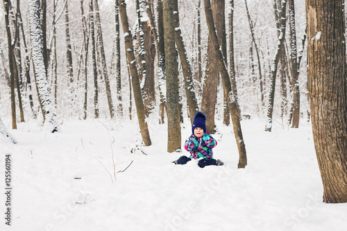 Happy little kid is playing in snow, good winter weather © satura_