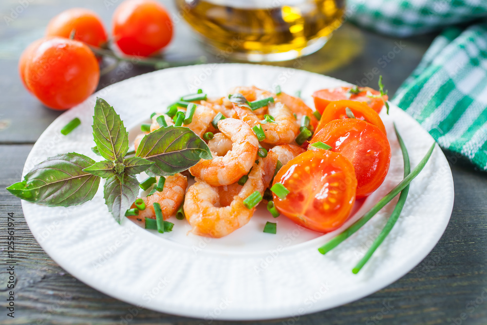 the cleared shrimps with tomatoes in a plate on a table, selective focus the cleared shrimps with tomatoes in a plate on a table, selective focus