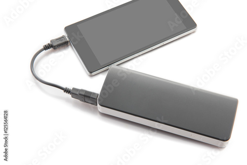 Smartphone charging with power bank on white background.