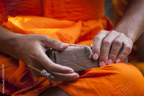 Photos Asian monk hand with orange tunic read the future in Angkor Wat temple, Cambodia