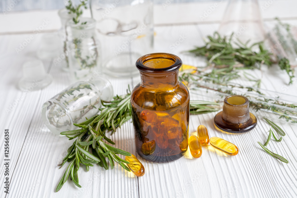 concept - natural medicine herbs in bottles on wooden background concept - natural medicine herbs in bottles on wooden background