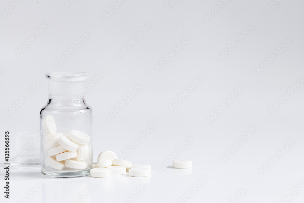pills in glass jar on white background pills in glass jar on white background