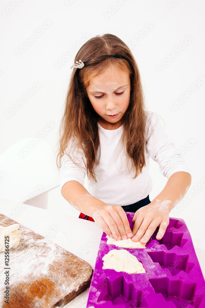 Little girl forming sweet cakes, white background. Lassie cooking bakery treat for family. Homemade cuisine, children culinary, pastry making concept Little girl forming sweet cakes, white background. Lassie cooking bakery treat for family. Homemade cuisine, children culinary, pastry making concept
