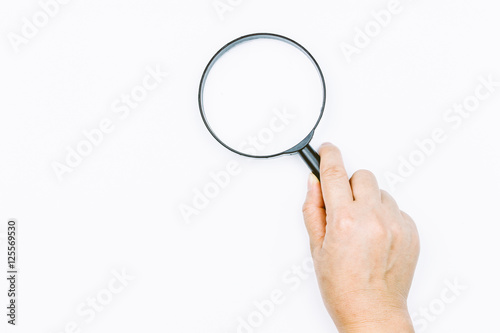 Hand holding magnifying glass on white background