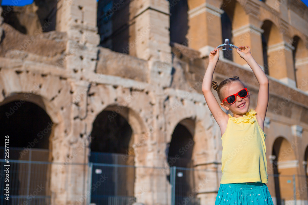 Girl with small toy model airplane on Colosseo background in Rome, Italy