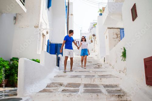 Family vacation in Europe. Happy couple at street of typical greek traditional village on Mykonos Island, in Greece