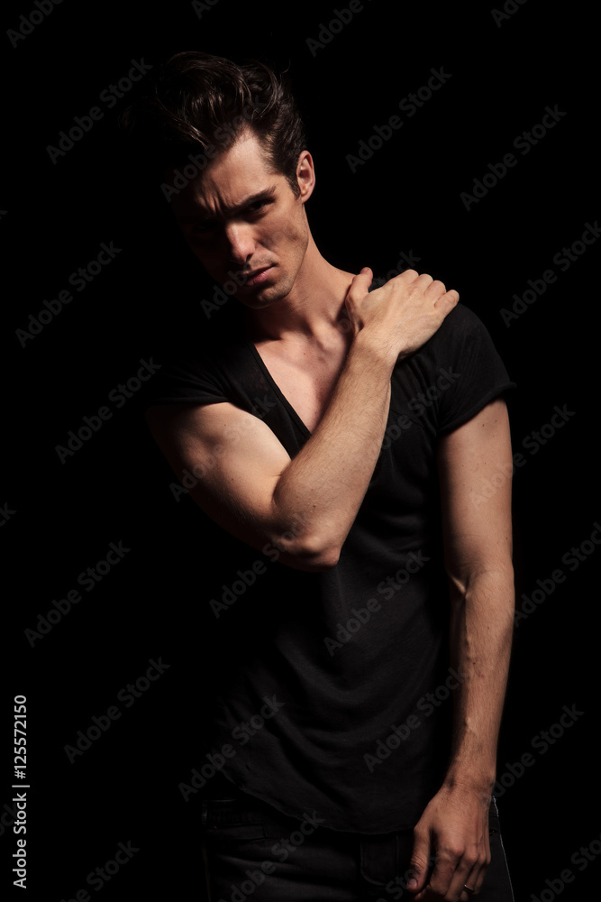 man in black shirt and jeans holding hand on shoulder man in black shirt and jeans holding hand on shoulder