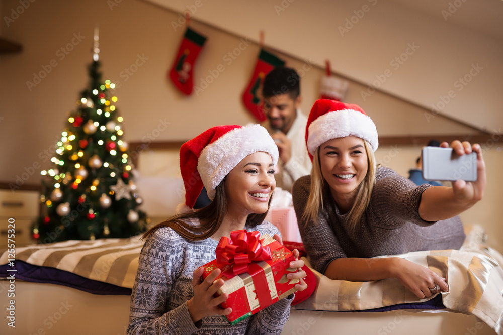 Women posing and taking a selfie with Christmas gift. Women posing and taking a selfie with Christmas gift.