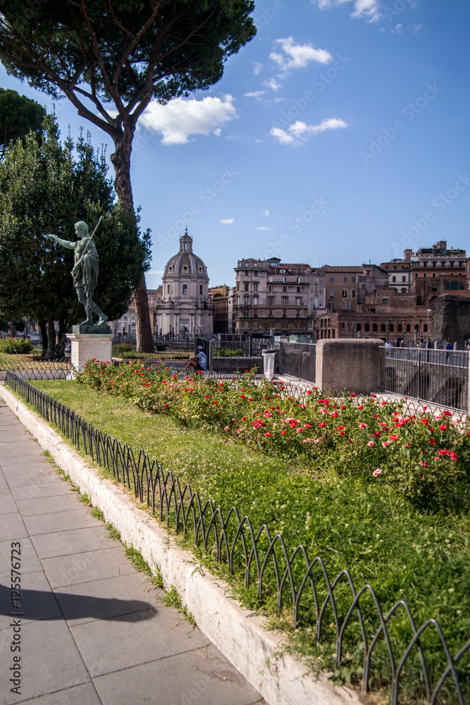 garden with flowers in front of old buildings in Rome
