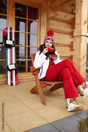 woman with cup of hot chocolate on mountain ski resort