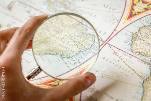 Magnifying Glass in Woman’s Hand and Ancient Old Map