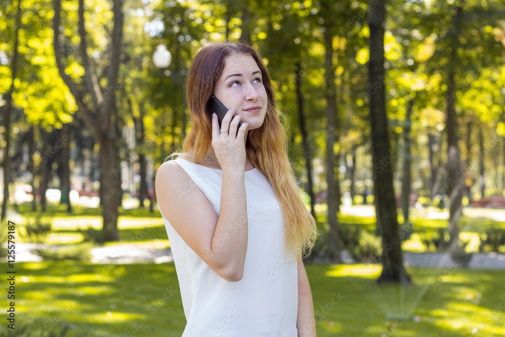 woman talking on the phone in the park woman talking on the phone in the park