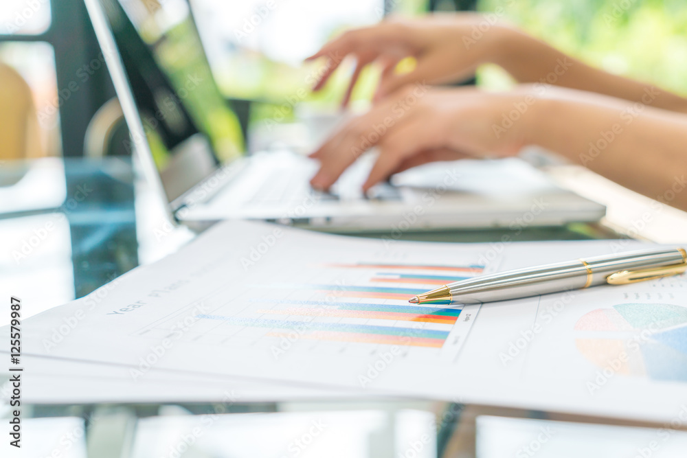 Business woman hand with Financial charts and laptop on the tabl Business woman hand with Financial charts and laptop on the tabl