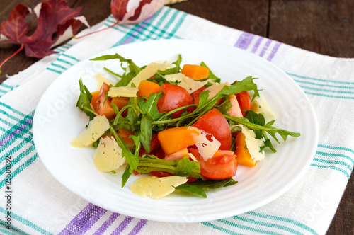 Dietary salad with pumpkin, fresh tomatoes, arugula and Parmesan.