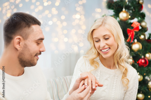 man giving woman engagement ring for christmas
