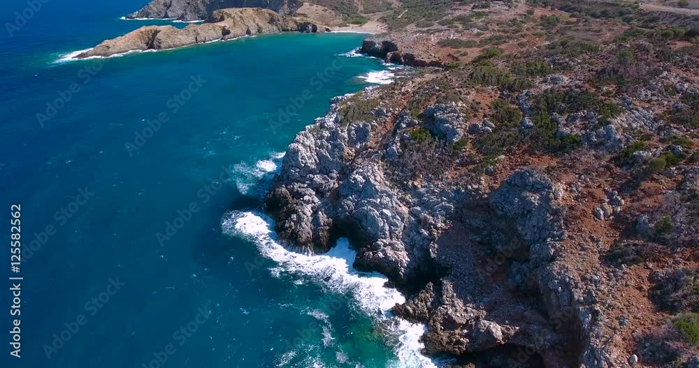 Blue sea, waves breaking in cliffs at shore Blue sea, waves breaking in cliffs at shore